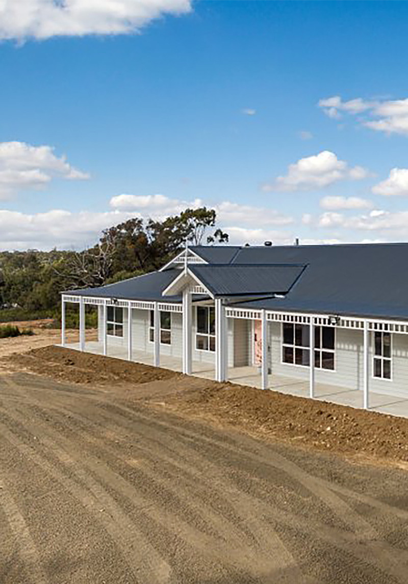 New home build in Eppalock with dark grey roof, light grey weatherboards and white trim