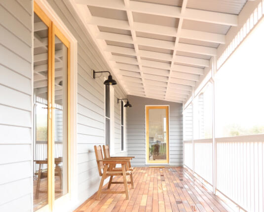 Verandah with timber flooring and white weatherboards of Bendigo home extension